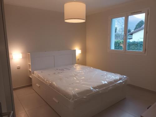 une chambre avec un lit blanc avec une fenêtre dans l'établissement Maison de Chamechaude, à Fontaine