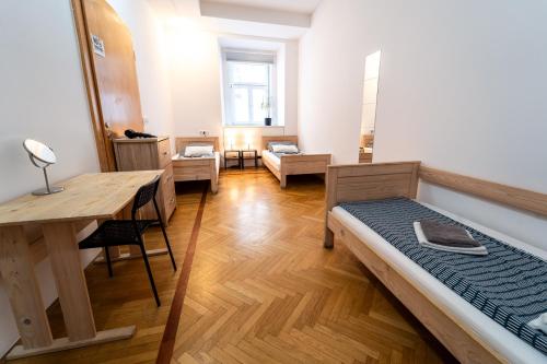 a room with a bed and a desk and a table at Anna House in Maribor