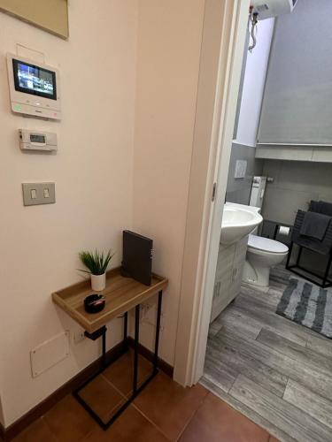a bathroom with a toilet and a desk with a computer on it at ROMA HOME in Udine