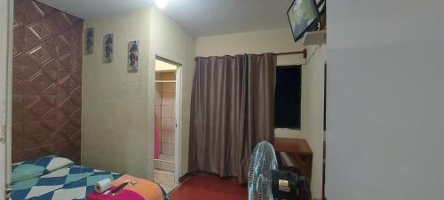 グアテマラシティにあるHotel Villas de San Juan, Guatemalaのベッドルーム1室(ベッド1台、デスク、窓付)