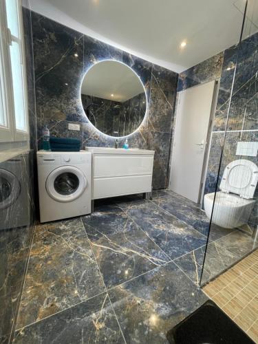 La salle de bains est pourvue d'un lave-linge et d'un miroir. dans l'établissement Agréable maison de ville à 500 mètres de la cité, à Carcassonne