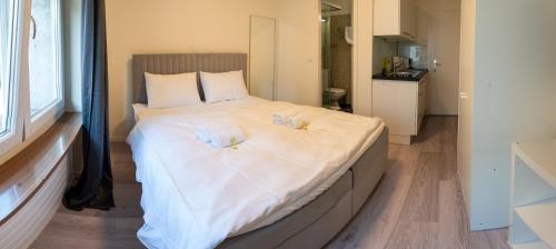 a bedroom with a large bed with towels on it at Urban Oasis with Queen Bed and View BE-13 in Zürich
