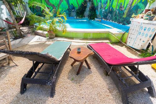 eine Gruppe von Stühlen, einem Tisch und einem Pool in der Unterkunft Zayali Bacalar - Guest House in Bacalar