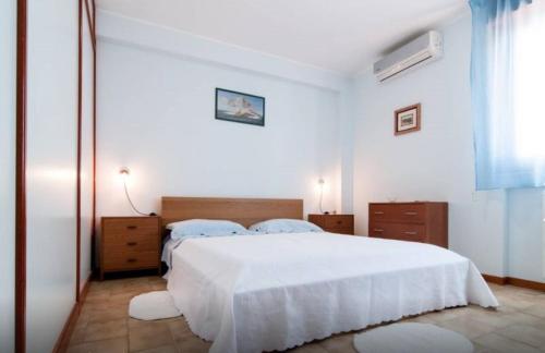 Un dormitorio blanco con una gran cama blanca y una ventana en App Sebastiano en Avola