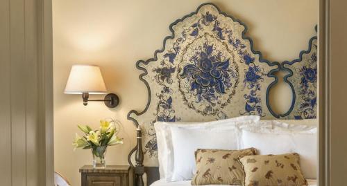 a bedroom with a bed with a blue and white headboard at La Fonda on the Plaza in Santa Fe