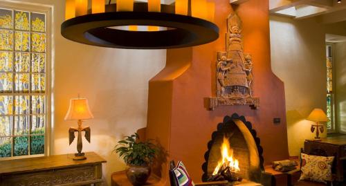 a living room with a fireplace and a chandelier at La Fonda on the Plaza in Santa Fe