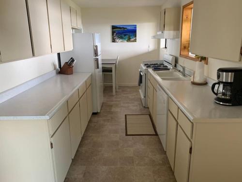 a kitchen with white cabinets and a white refrigerator at Tahoe Lake View Hill Top Retreat in Incline Village