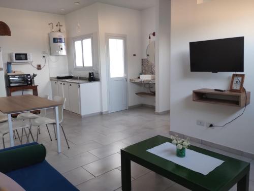 a living room with a couch and a table and a kitchen at El Balconcito Dos ambientes in Saladillo