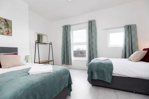 a bedroom with two beds and a window at Urban Chic in Hartlepool