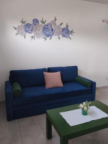 a living room with a blue couch and a table at El Balconcito Dos ambientes in Saladillo