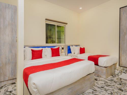 two beds in a room with red and white at Hotel Good Luck Residency- Near Nesco in Mumbai