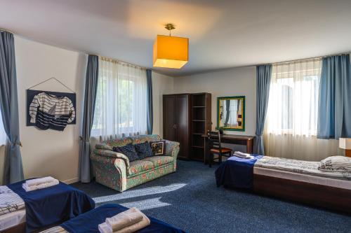 a hotel room with two beds and a couch at B&B NAUTIC - Jezioro Mamry, Green Velo in Węgorzewo