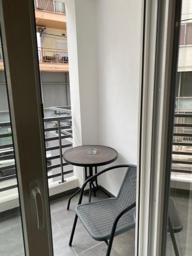 a small table and a chair in a room with a balcony at Brand new studios Η1-Η2-Η3 in Larisa