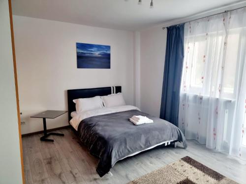 a bedroom with a bed and a table in it at Feel Like Home in Piatra Neamţ