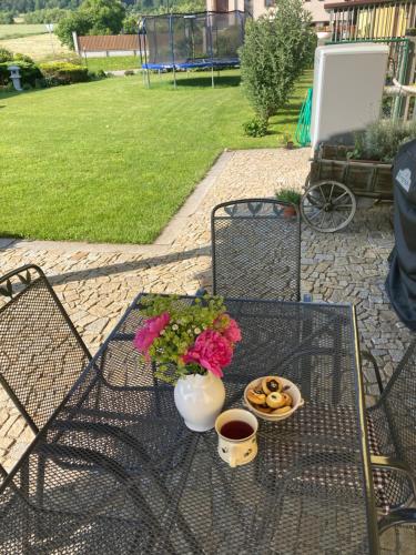 a table with a vase of flowers and a bowl of pretzels at Apartmán Dolánek in Jankov