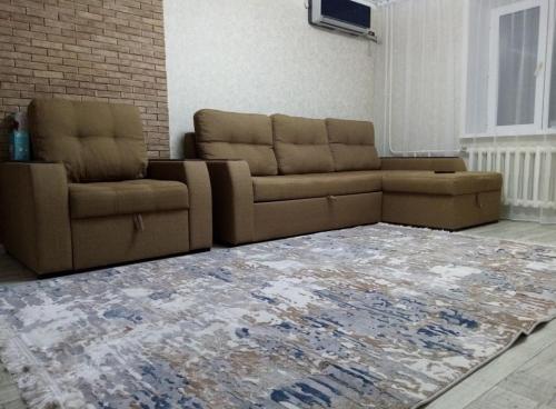 een woonkamer met 2 banken en een tapijt bij Уютная 3-х комнатная квартира in Oral