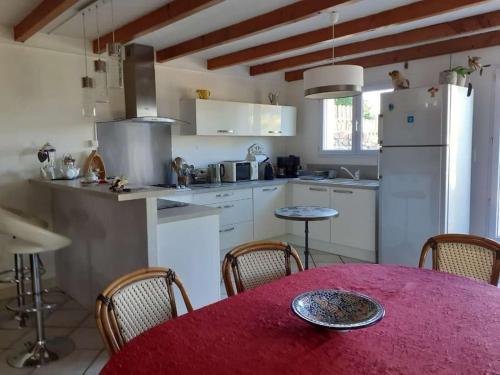 une cuisine avec une table et un chiffon rouge dans l'établissement Penty Breton proche mer Beg Meil, à Fouesnant