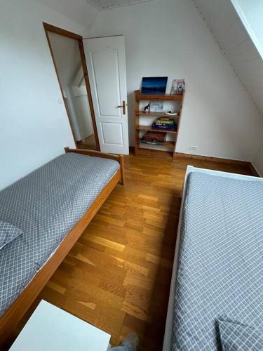 une chambre avec deux lits et un placard dans l'établissement Penty Breton proche mer Beg Meil, à Fouesnant