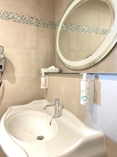 a bathroom with a sink and a mirror at Hôtel Le Royal Promenade des Anglais in Nice