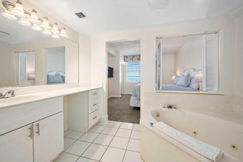 baño blanco con bañera y espejo grande en Luxury 10th Floor 3 BR Condo Direct Oceanfront Wyndham Ocean Walk Resort Daytona Beach | 1011, en Daytona Beach