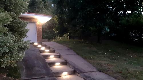 a pathway with lights in a yard at night at RENATA, tu alojamiento en Piriápolis in Piriápolis