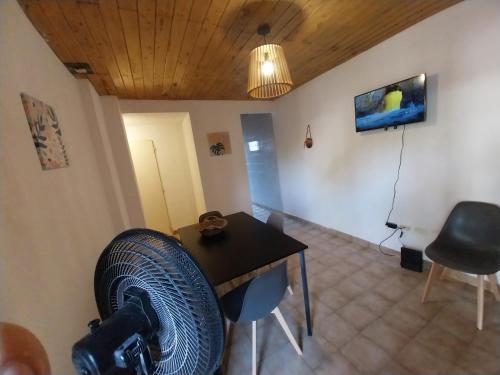 Cette chambre comprend une table et un ventilateur. dans l'établissement Casita Mutisia, à Neuquén