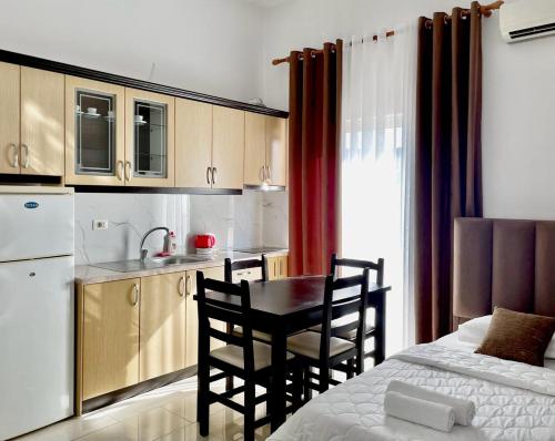 a kitchen with a table and chairs in a room at Four Seasons Apartments in Ksamil