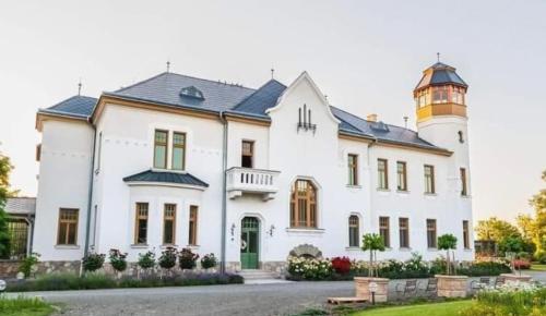 uma grande casa branca com um farol no topo em GRAEFL MAJOR Kétútköz em Poroszló