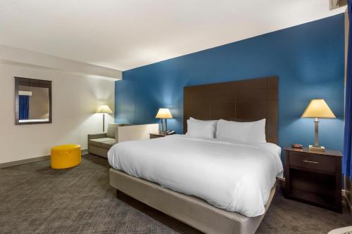 a bedroom with a large bed and a blue wall at Comfort Inn & Suites Mundelein-Vernon Hills in Mundelein