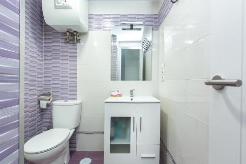 La salle de bains blanche est pourvue de toilettes et d'un lavabo. dans l'établissement VER3 - Piscinas - Fire Stick TV - 10 min Playa -Reformado, à Torremolinos