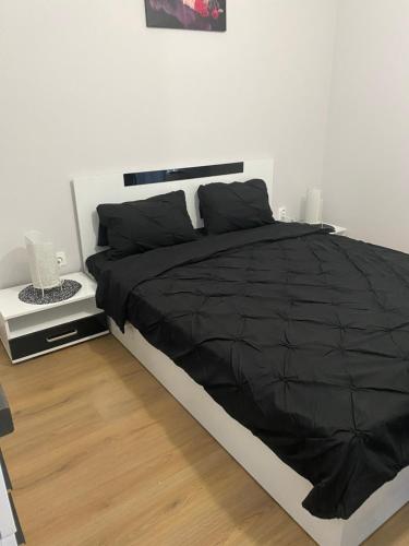 - une chambre avec un lit et une couette noire dans l'établissement Studio VIP in BLagoevgrad center, à Blagoevgrad