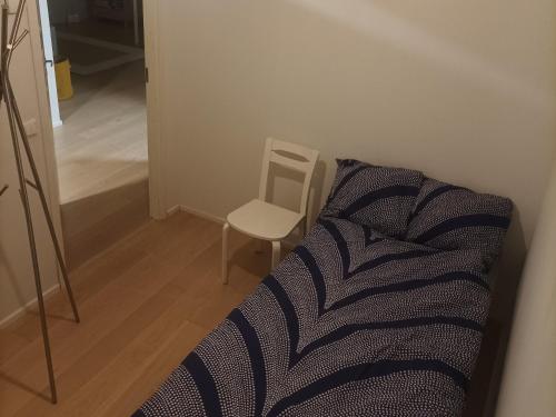 1 dormitorio con 1 cama y 1 silla en 2BR and LuxurySauna, en Tornio