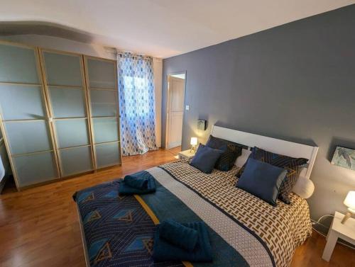 une chambre avec un grand lit avec des oreillers bleus dans l'établissement La casa del cielo, à Toulouse