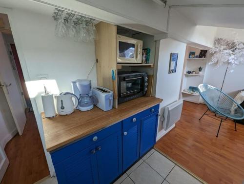 - une cuisine avec des placards bleus et un four micro-ondes dans l'établissement La casa del cielo, à Toulouse