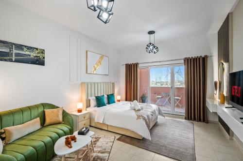 a bedroom with a bed and a green couch at Luxurious Apt Near Jbr in Dubai