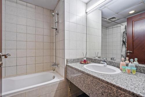 a bathroom with a sink and a bath tub at Luxurious Apt Near Jbr in Dubai