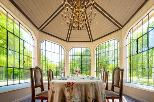 a dining room with a table and a chandelier at GRAEFL MAJOR Kétútköz in Poroszló