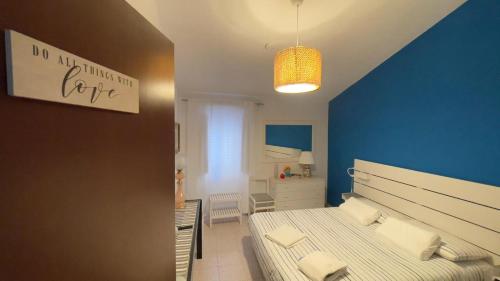 a bedroom with two beds and a blue wall at Itiseasy Cuglieri 1 e 2 Private Apartments in Cuglieri