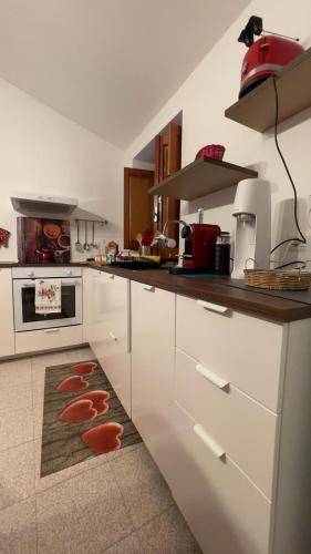 a kitchen with white cabinets and a rug on the floor at Itiseasy Cuglieri 1 e 2 Private Apartments in Cuglieri