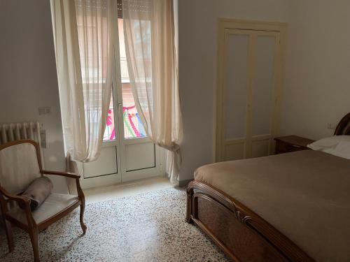 a bedroom with a bed and a chair and a window at CA12 casa vacanze in Putignano