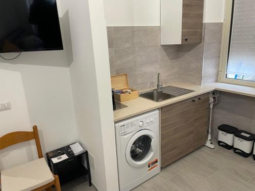 a kitchen with a washing machine and a sink at CA12 casa vacanze in Putignano