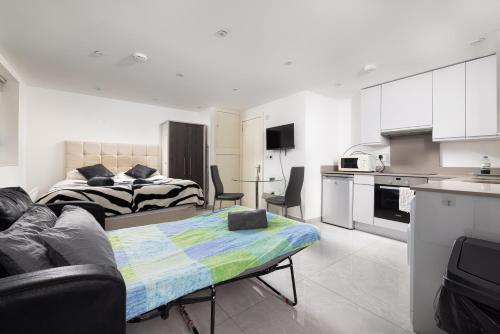 een woonkamer met een bed en een keuken bij Garden Studio flat in Hendon in Hendon