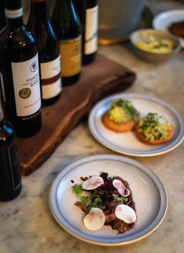 two plates of food on a table with bottles of wine at Ski Lodge Engelberg in Engelberg