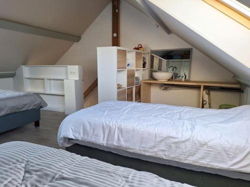 1 dormitorio en el ático con 2 camas y barra en Vakantiehuis Latfin, en Middelkerke