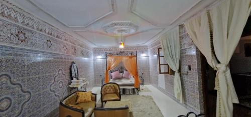 een kleine kamer met een bed en stoelen erin bij Riad Raffaa in Marrakesh