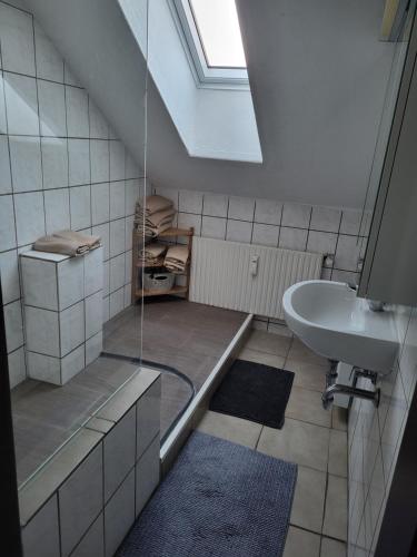a bathroom with a tub and a sink and a window at Ferienwohnung in Hövelhof