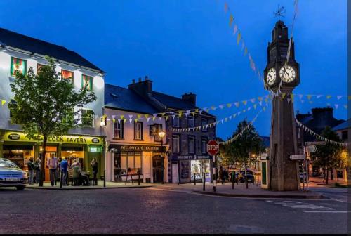 a clock tower in the middle of a town at night at The Croft Apartment in Westport