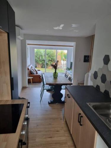 - une cuisine avec une table au milieu d'une pièce dans l'établissement Villa les pieds dans l'eau résidence calme, à Poggio-Mezzana