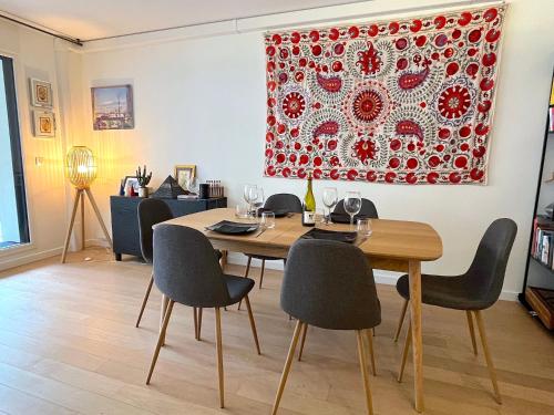 une salle à manger avec une table et des chaises dans l'établissement Le Penthouse de Levallois, à Levallois-Perret
