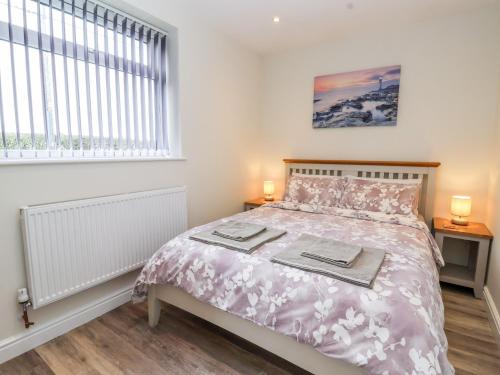 a bedroom with a bed and a window at Ashtree Cottage in Hull